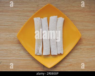 Assamesische Speisen, bekannt als Pitha, zubereitet während des Bihu Festivals in Assam. Pitha wird mit Reismehl zubereitet, gefüllt mit schwarzem Sesam und Jaggery Stockfoto