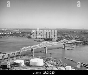 Outerbridge überquert die Brücke, die sich an der Skyline von Manhattan in der Mitte des Horizonts befindet, Verrazano Narrows Bridge auf der rechten Seite - Outerbridge überquert die Brücke, die Arthur Kill von New Jersey bis Staten Island, Staten Island (Unterteilung), Richmond County, NY, 1991 umfasst Stockfoto