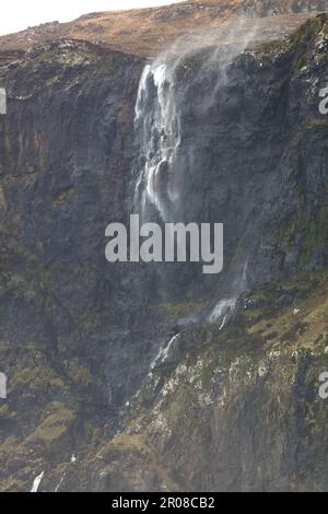 Wasserfall, der während eines Sturms wieder auf die Klippe gejagt wird. Talisker Bay, Isle of Skye, Schottland, Großbritannien. Stockfoto