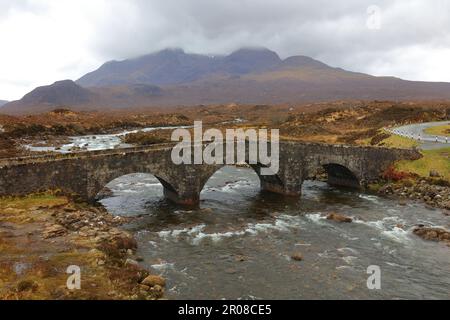 Alte Brücke in Sligachan mit den Cuilin-Gebirgsregionen im Hintergrund, Isle of Skye, Schottland, Großbritannien. Stockfoto