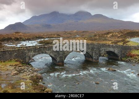 Alte Brücke in Sligachan mit den Cuilin-Gebirgsregionen im Hintergrund, Isle of Skye, Schottland, Großbritannien. Stockfoto