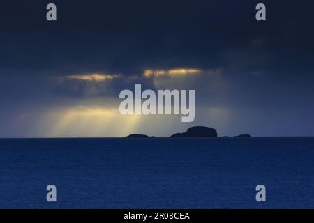 Krepuskuläre Rochen am Horizont bei Sonnenuntergang, Duntulm, Isle of Skye, Schottland, Großbritannien. Stockfoto