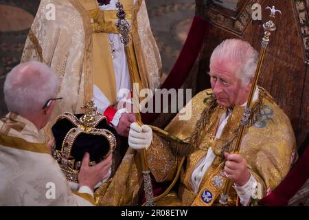 König Karl III. Wird gekrönt mit St. Edwards Krone vom Erzbischof von Canterbury, dem größten Reverend Justin Welby, während er in St. Edwards Stuhl sitzt, auch bekannt als Krönungsstuhl, Und während seiner Krönungszeremonie in Westminster Abbey, London, das Zepter des Herrschers mit der Taube (in der linken Hand) und das Zepter des Herrschers mit Kreuz (in der rechten Hand) halten. Foto: Samstag, 6. Mai 2023. Stockfoto