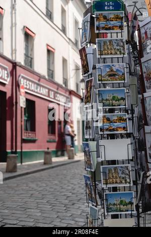 Kaufen Sie in Paris ein und bieten Sie verschiedene Postkarten von Paris in Montmartre an. Stockfoto