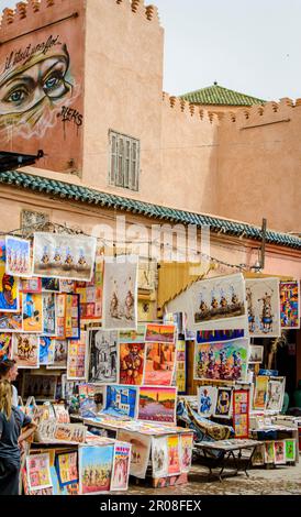 Marrakesch, Marokko, 8. April 2023. Ein Kunstgeschäft mit bunten Gemälden in der Marrakesch Medina an einem sonnigen Tag. Stockfoto