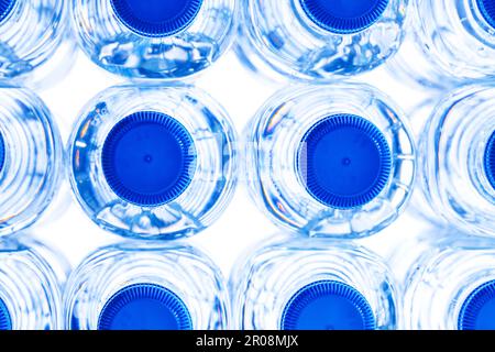 Gruppe kleiner Kunststoff-Wasserflaschen mit blauem Verschluss. Stockfoto