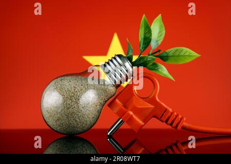 Stöpsel, Pflanze wächst in der Glühbirne und Vietnam-Flagge. Konzept für umweltfreundliche erneuerbare Energien. Stockfoto