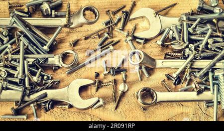Gruppe von Schrauben und Schraubenschlüssel. Schrauben, Muttern, Schrauben, Schlüssel und Ring Strecker in einem Stapel auf natürlichen hölzernen Hintergrund. Stockfoto