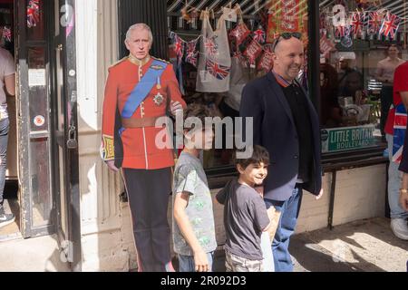 New York, Usa. 06. Mai 2023. NEW YORK, NEW YORK - 6. MAI: Die Leute posieren mit dem Ausschnitt seiner Majestät König Charles III. Vor dem britischen Tea & Sympathy Restaurant in Manhattan Greenwich Village am 6. Mai 2023 in New York City. Die Krönung Karls III. Und seiner Frau Camilla als König und Königin des Vereinigten Königreichs Großbritannien und Nordirland und der anderen Commonwealth-Reiche findet heute in Westminster Abbey statt. Karl trat am 8. September 2022 auf den Thron, nach dem Tod seiner Mutter, Elizabeth II. Kredit: Ron Adar/Alamy Live News Stockfoto