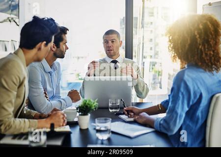 Lassen Sie mich Ihnen sagen, was ich denke... eine Gruppe von Kollegen, die sich im Sitzungssaal treffen. Stockfoto