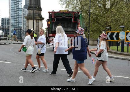 Die gut gepflegten Gäste für die Krönung von König Karl III. Kommen früh an der Lambeth Bridge an und begeben sich zu den Victoria Tower Gardens in London Stockfoto