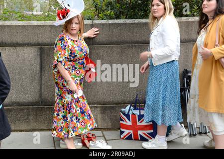 Die gut gepflegten Gäste für die Krönung von König Karl III. Kommen früh an der Lambeth Bridge an und begeben sich zu den Victoria Tower Gardens in London Stockfoto