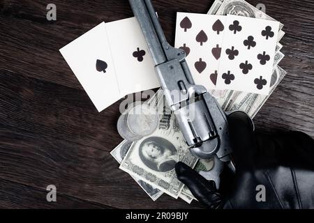 Die Hand eines Toten. Zweipaarige Pokerhand bestehend aus schwarzen Assen und schwarzen Achten und Spielerhand mit Revolver. Stockfoto