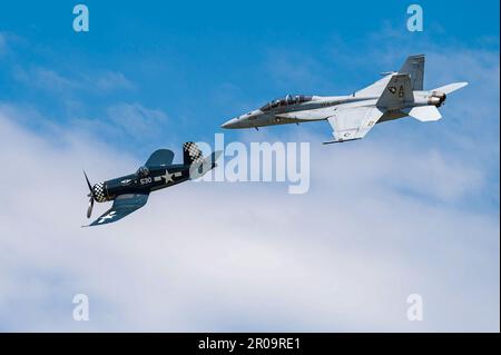 EIN US-AMERIKANISCHER Navy F/A-18 Super Hornet tritt zusammen mit einem F-4U Corsair Bearcat während der Air Power über Hampton Roads auf der Joint Base Langley-Eustis, Virginia, am 6. Mai 2023 auf. Bekannt für seine Geschwindigkeit, Robustheit und Feuerkraft wurde die F-4U aus der Zweiten Weltkrieg-Ära von feindlichen Kräften wegen des Klangs, den sie beim Tauchen machten, als „der Pfeiftod“ bezeichnet, und die größere, modernere F/A-18 erhielt den Spitznamen „Nashorn“ für ihre unverwechselbare Nase. (USA Air Force Foto von Senior Airman Chloe Shanes) Stockfoto