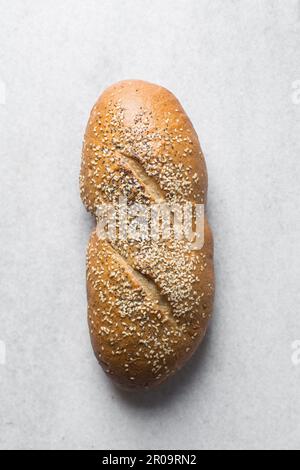 Ein Laib mit hausgemachtem Brot garniert mit Sesamsamen auf einer Marmorarbeitsfläche, Blick von oben auf Sesambrot, Sandwichbrot auf einem weißen Tablett Stockfoto