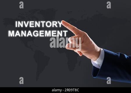 Mann berührt virtuellen Bildschirm mit Text Inventory Management auf farbigem Hintergrund Stockfoto