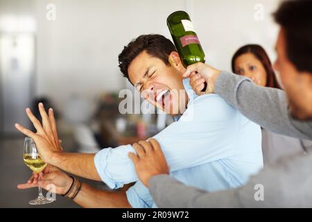 Gewalttätig und unberechenbar - schlechte Trinkgewohnheiten. Ein betrunkener Mann, der ein Glas Wein in der Hand hält und mit einer Flasche Wein über den Kopf geschlagen wird. Stockfoto