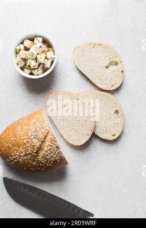 Scheiben hausgemachtes Brot, Sesam-beschichtete Brotscheiben auf einem Marmortablett, Sandwich-Brotscheiben auf einem Tablett Stockfoto