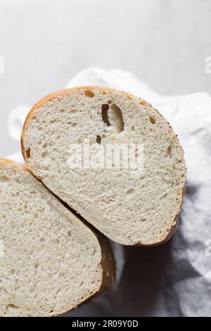 Querschnitt von in zwei Hälften geschnittenem, Draufsicht von Sesambrot Querschnitt, Sandwichbrot auf einer Leinenserviette Stockfoto