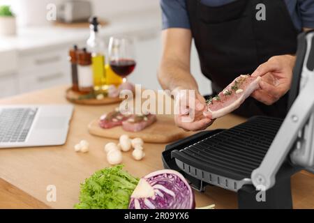 Mann macht Abendessen in der Küche, Nahaufnahme. Online-Kochkurs Stockfoto