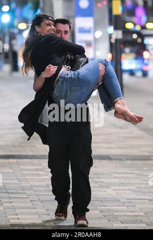 Broad Street, Birmingham, 8. Mai 2023 - Sonntagabend stiegen Reveller auf Birminghams Broad Street ab, um eine königliche Afterparty zu feiern. Die Polizei war auch draußen und musste einen Mann zu Boden ringen, nachdem er sich nach einem Vorfall in einem Nachtclub der Verhaftung widersetzte. Die Polizei war auch bei mehreren anderen Vorfällen entlang des berüchtigten Streifens dabei, als temperiert wurde. Eine Frau wurde von einem Sanitäter in einen Krankenwagen gefahren, der einen Krankenwagen hielt. Die meisten Feiernden trugen normale Wochenend-Outfits, aber einige hielten sich immer noch an den Feierlichkeiten fest, die Union Flag Hüte und König Karl III Masken und großes Ohr trugen Stockfoto