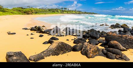 Am Sandy Shore von Donkey Beach, Kauai, Hawaii, USA, waschten sich Wellen über Lavafelsen Stockfoto