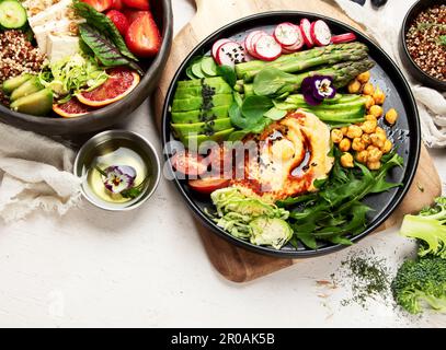 Gesunde vegetarische und vegane Salate und Buddha-Schalen mit Vitaminen, Antioxidantien, Proteinen auf hellem Hintergrund. Draufsicht, Kopierbereich Stockfoto