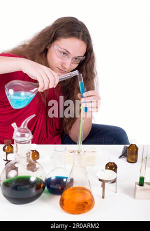 Bildungskonzept - kleine Kinder von Wissenschaftlern schauen auf einen Erlenmeyerkolben mit Chemikalien, um Experimente im Labor durchzuführen Stockfoto