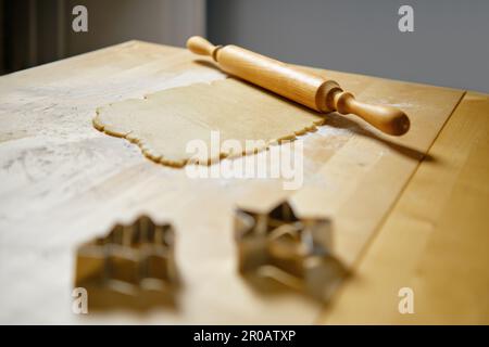 Flacher Ingwerteig auf dem Küchentisch und Rollnadel (Foto mit selektivem Fokus) Stockfoto