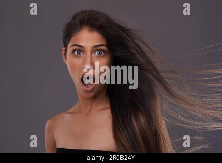 Was du meinst, du konditionierst nie. Porträt einer attraktiven jungen Frau mit Windhaar im Studio. Stockfoto