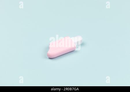 Nahaufnahme eines pinkfarbenen Eis am Stiel auf Cyan-Oberflächeneis Stockfoto