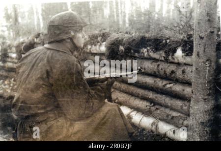 Schwarzweiß-Foto des Zweiten Weltkriegs Ein Waffen-SS-Soldat in defensiver Position bewaffnet mit einem MP40. Das ist ein privates Foto von This man's Personal Album. Da ihr Name im Album nicht erwähnt wird, diente er nur in der sechsten SS-Division Nord und überlebte den Krieg Stockfoto