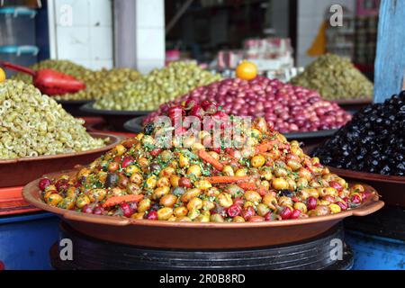Gepiekelte Oliven mit Gewürzen, heißem Paprika und Karotten auf einem traditionellen marokkanischen Markt (Souk), Rabat, Marokko Stockfoto