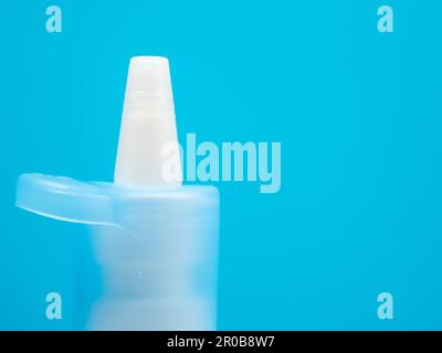 Nasenspray-Flaschen auf blauem Hintergrund, Behandlung einer Erkältung mit Nasenspray. Medizin-Nahaufnahme. Stockfoto