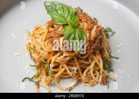 Portion hausgemachter Spaghetti Bolognese, serviert auf Keramikplatte. Stockfoto