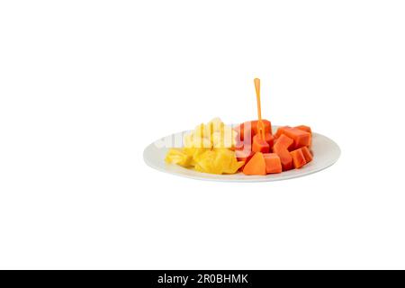 Kiefernapfel und Papaya-Scheibe in Schüssel auf weißem Hintergrund. Stockfoto