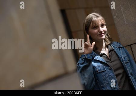 PRODUKTION - 06. Mai 2023, Hessen, Frankfurt/Main: Die Schauspielerin Annalisa Weyel bildet die Geste für "Ich liebe dich", die auch als Zeichen der Solidarität in der Gemeinschaft hörender Kinder gehörloser Eltern (Coda - Kinder gehörloser Erwachsener) verwendet wird. (Zu dpa: 'Annalisa Weyel: Nur taube Schauspieler sollten Taube spielen') Foto: Sebastian Gollnow/dpa Stockfoto