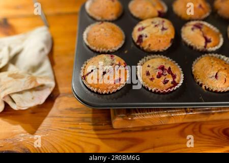 Frisch gebackene Bio-Cupcakes mit Himbeeren auf Holztabletten Stockfoto