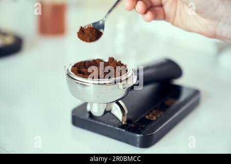 Frisch gemahlener Espresso wird auf einer Skala gemessen. Stockfoto