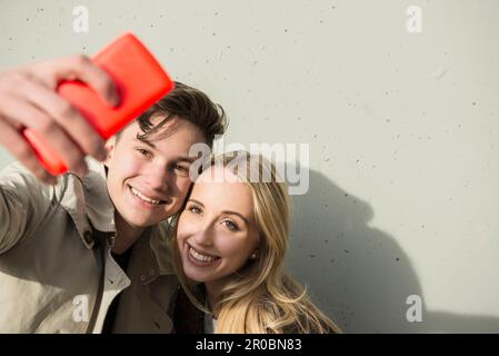 Ein junges Paar, das ein Selfie mit dem Smartphone macht, München, Bayern, Deutschland Stockfoto