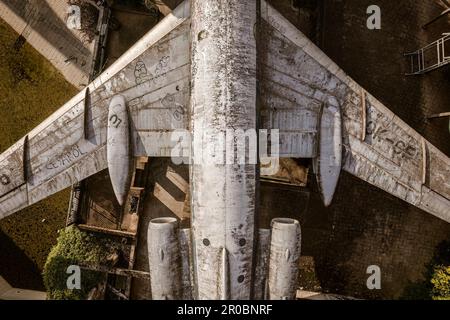 Ein fesselndes Luftfoto eines verlassenen Flugzeugs aus einer Top-Down-Perspektive, das seine Isolation und Verfall offenbart. Stockfoto