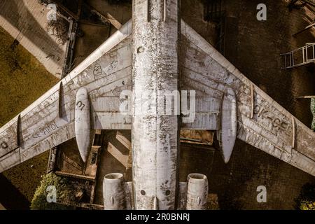 Ein fesselndes Luftfoto eines verlassenen Flugzeugs aus einer Top-Down-Perspektive, das seine Isolation und Verfall offenbart. Stockfoto