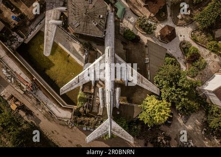 Ein fesselndes Luftfoto eines verlassenen Flugzeugs aus einer Top-Down-Perspektive, das seine Isolation und Verfall offenbart. Stockfoto