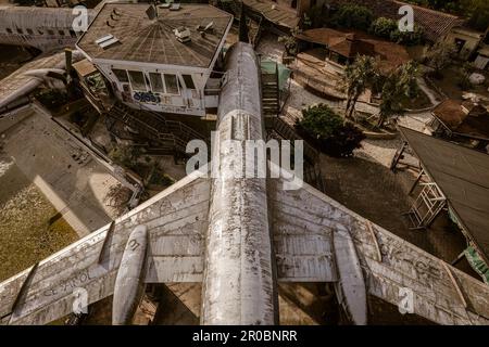 Ein fesselndes Luftfoto eines verlassenen Flugzeugs aus einer Top-Down-Perspektive, das seine Isolation und Verfall offenbart. Stockfoto