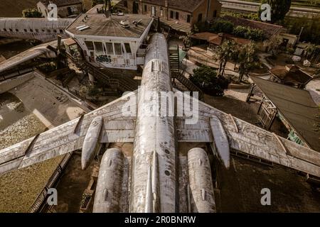 Ein fesselndes Luftfoto eines verlassenen Flugzeugs aus einer Top-Down-Perspektive, das seine Isolation und Verfall offenbart. Stockfoto