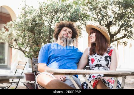 Ein junges Paar sitzt im Restaurant draußen Stockfoto