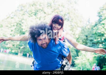 Junger Mann mit seiner Freundin eine Huckepack Fahrt Stockfoto