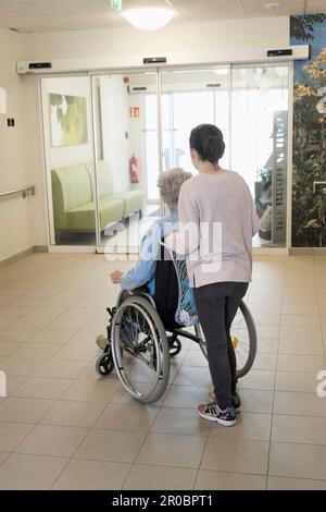 Seniorin im Rollstuhl mit Mädchen im Altersheim Stockfoto