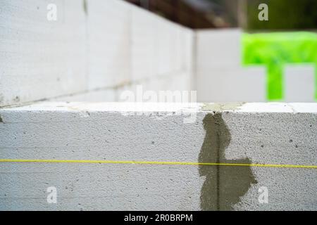 Nahaufnahme einer frisch gebauten Porenbetonsteinwand. Hochwertiger, gleichmäßiger Mauerwerk-Gasblock während der Bauphase Stockfoto