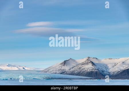 Panoramablick über die gefrorene Gletscherlagune mit dem Endpunkt oder dem Ende des Jokulsarlon-Gletschers, Island mit schneebedeckten Bergen Stockfoto